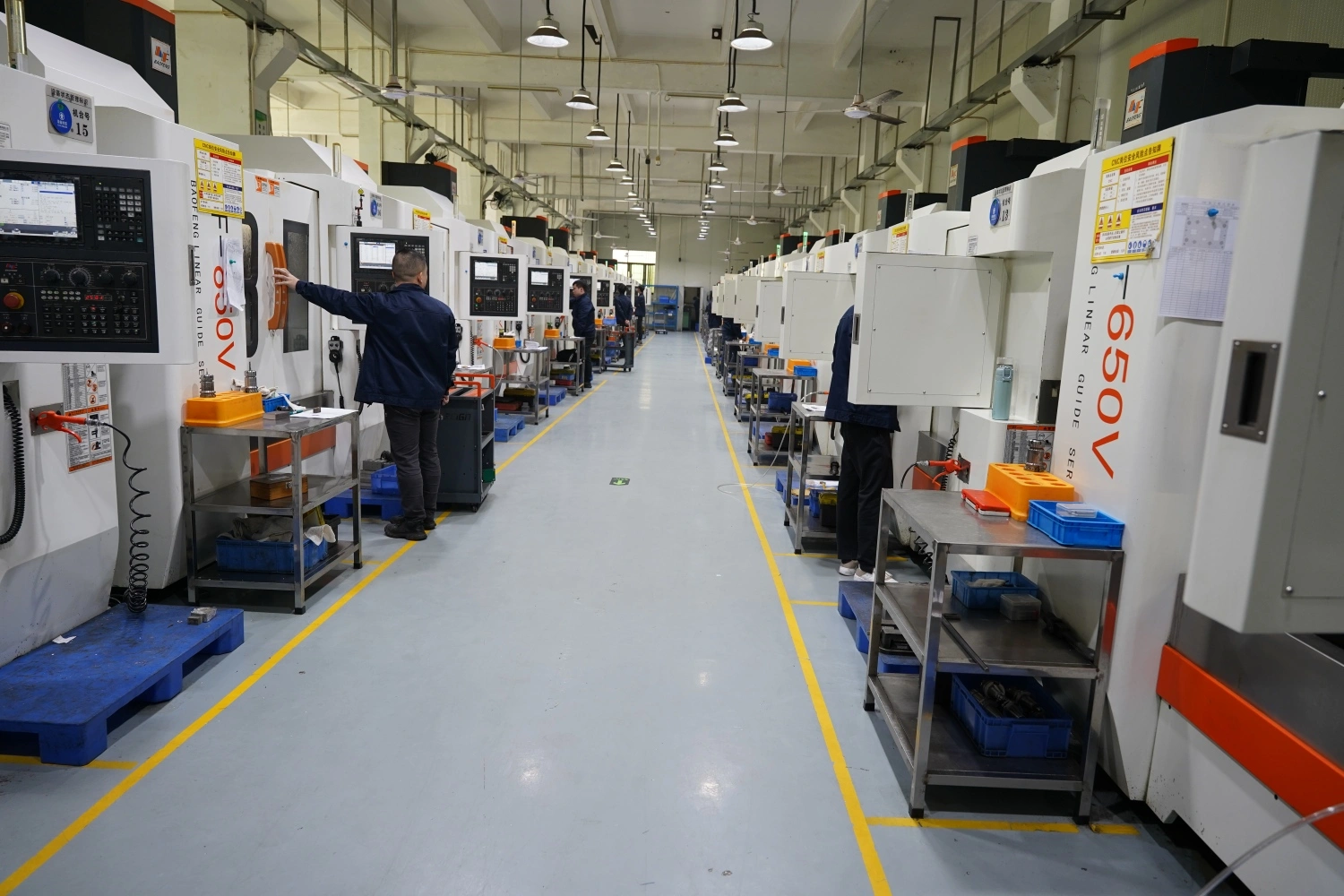 CNC machining workshop with multiple machines and operators
