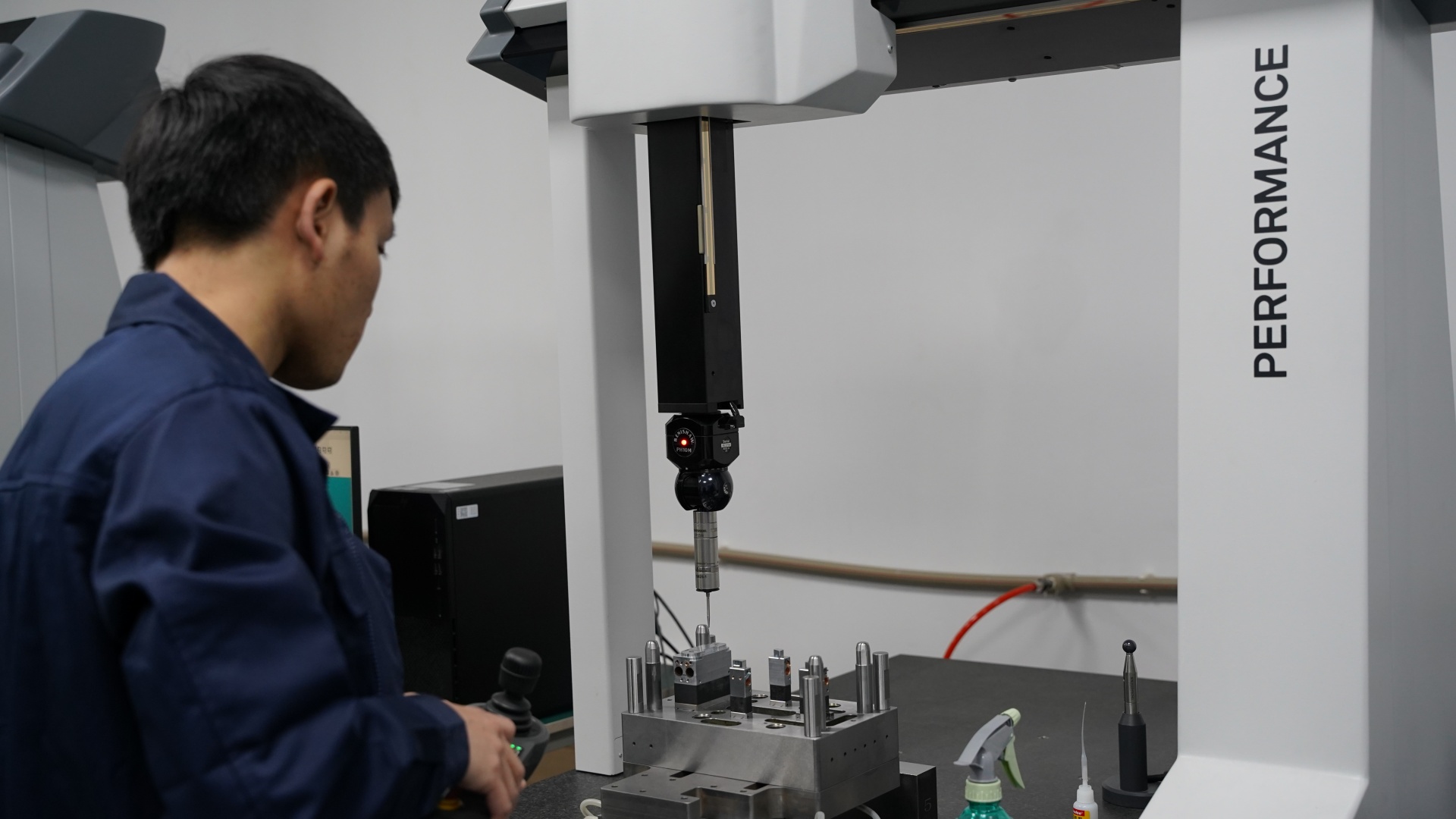 Quality inspector using a CMM machine to verify CNC part accuracy
